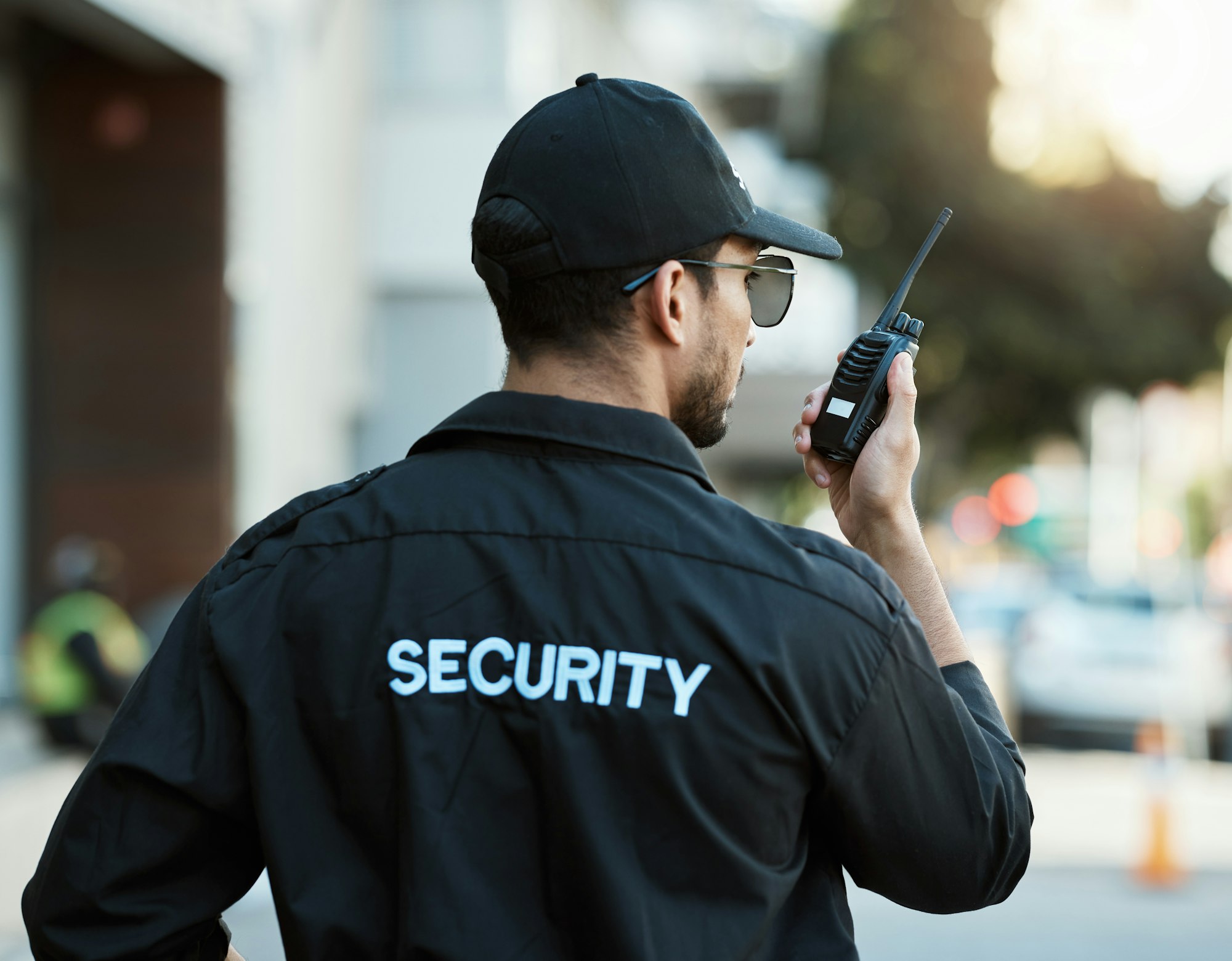 Radio, man and a security guard or safety officer outdoor on a city road for communication. Back of